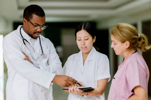 istock Doctors And Nurse Talking To Each Other While Standing In A  Hospital Corridor 1420069762