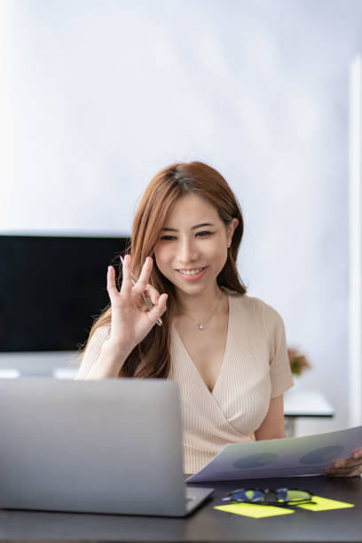 istock Asian woman working at home on laptop computer manages her business at work. Document planning, calculator, analyze financial reports. business plan investment 1420069978