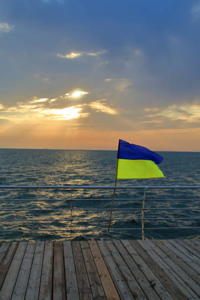 flag of ukraine at sunrise over the sea. - cyclone fence imagens e fotografias de stock