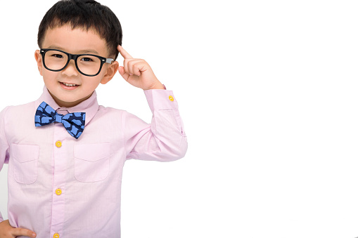 kid standing over white background smiling and  pointing to head with one finger