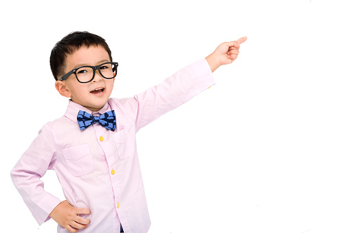 Happy child in a suit  and pointing to copy space