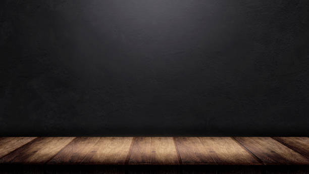 istock Rustic interior, old wood floor and old concrete wall background. Old wood table with blurred concrete block wall in dark room background 1420070884