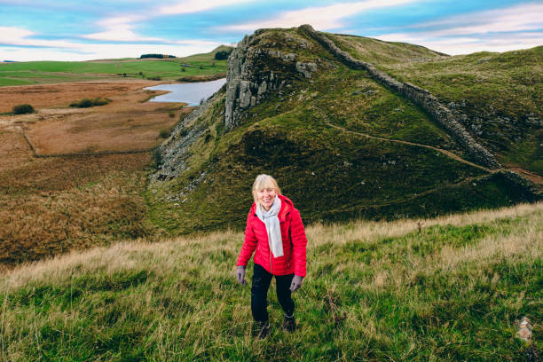 Woman walking Hadrian's Wall in the Northumberland region of the United Kingdom. This section is just west of Sycamore Gap.