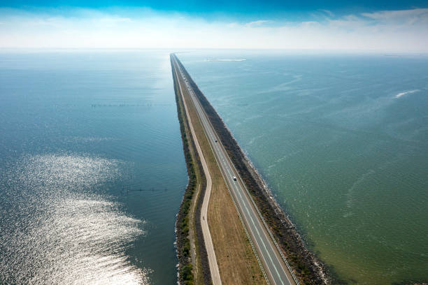 Dutch engenering: 26 km long dyke in the IJsselmeer, the Netherlands Drone panorama photography of an dyke called Houtrib dijk in Lake Markermeer in the province Flevoland. The highway dyke N302 from Lelystad to Enkhuizen. enkhuizen stock pictures, royalty-free photos & images