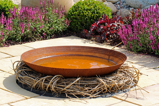 Large bowl of water in a vegetable and flower garden.