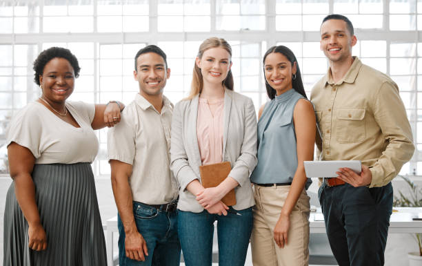 istock Happy, smiling and diverse team of business people standing in unity, supporting and working together in a modern office at work. Portrait of workers, employees and colleagues planning a project 1420084613