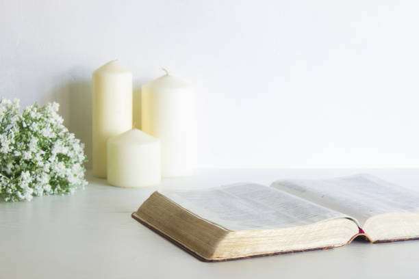 istock Book with white flowers and candles over the white wall. 1420084679