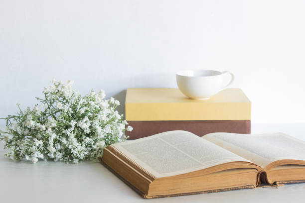istock Various books with white flowers and coffee cup over the white table. 1420084695