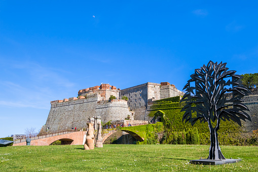 The Priamar Fortress (Fortezza del Priamar) of Savona is a fortress occupying the hill with the same name, built in 1542 by the Republic of Genoa. The green space facing the fortress is the right venue for art installations by various artists in rotation. In foreground: 'L'Albero di Ferro', by Mario Rossello dated 1994 and 'Odalische', by Claudio Carrieri dated 2009-2010