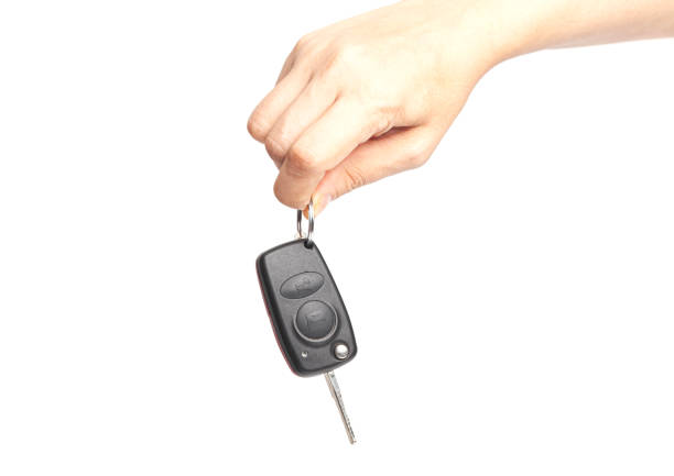 istock Car key in woman's hand isolated on white background 1420088238