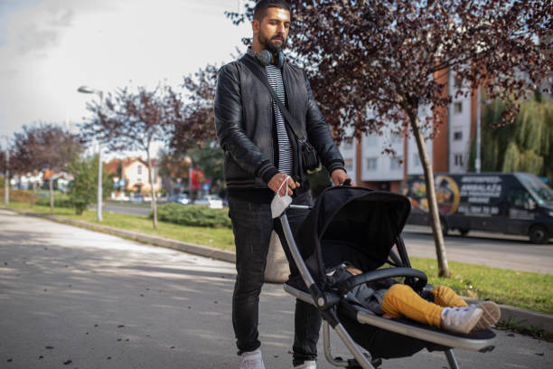 istock Father pushing toddler in a stroller 1420090317