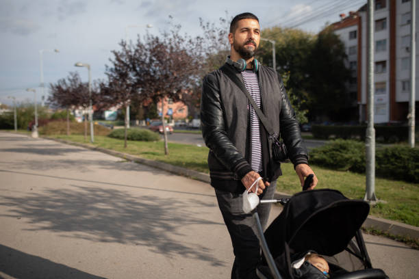 istock Happy father pushing toddler in a stroller 1420090356