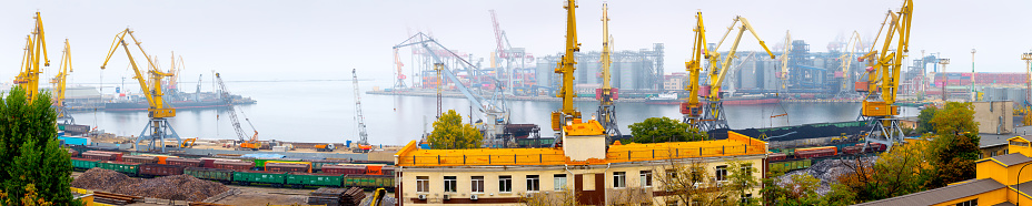 Odesa, Ukraine - OCT 22 2019: Autumn fog in the sea cargo port. Gantry cranes, level luffing cranes in the container terminal and terminal for grains of wheat, soy and other grains and oilseeds
