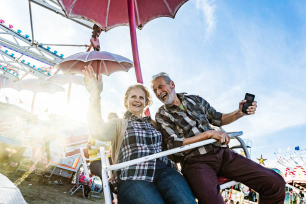 Happy senior couple having fun while riding at amusement park.