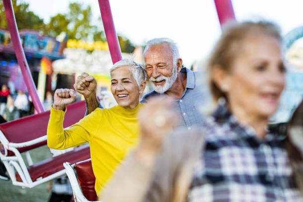 istock Happy senior couple having fun while riding at amusement park. 1420094266