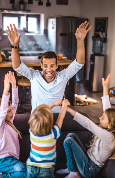 istock Cheerful single father having fun with his children at home. 1420094348