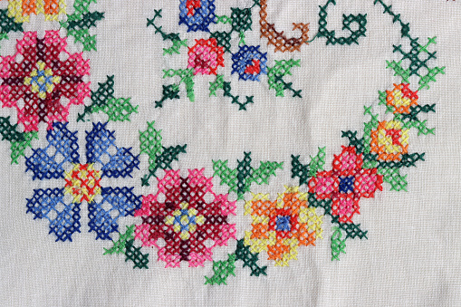 Embroidered table cloth close up photo. Beautiful flower pattern detailed photo. Stitch embroidery design.