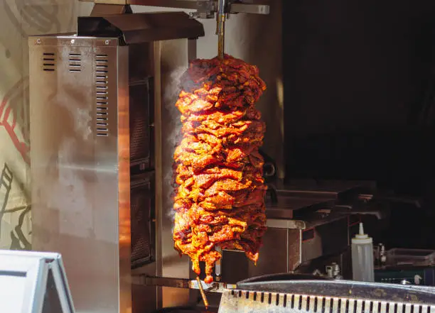 Middle East grilled skewered lamb mutton, close up smoked meat for shawarma or kebab. Fast food home delivery.