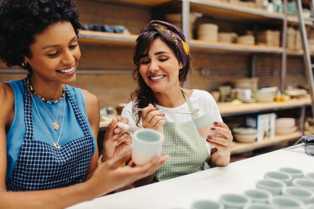 手作りのセラミックカップを飾る幸せな若い職人 - potter small business pottery happiness ストックフォトと画像