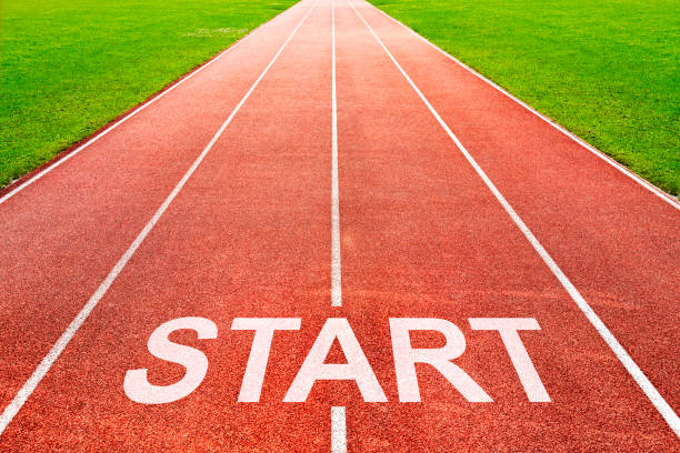 Start written on starting line on of running track of sports field stock photo