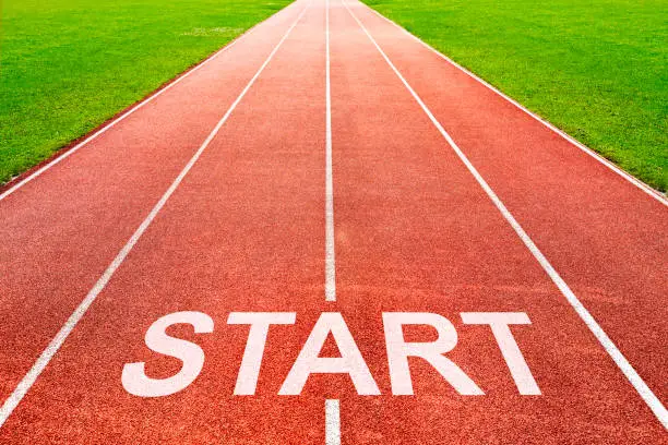 Start written on race starting line on of running track of stadium sports field