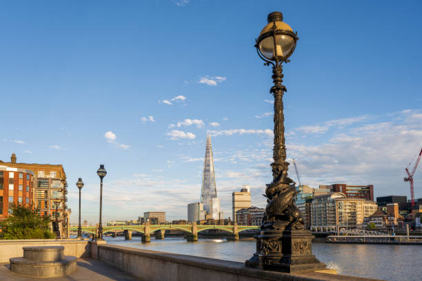 View from Thames Embankment to Southwark Focus on 19th-century stylized sturgeon lamp post in foreground with Southwark district, arch bridge, and landmark skyscraper The Shard in background. southwark stock pictures, royalty-free photos & images