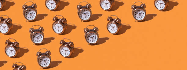 istock Pattern of an alarm clock on a colored background. Creative time concept. Banner format. 1420111428