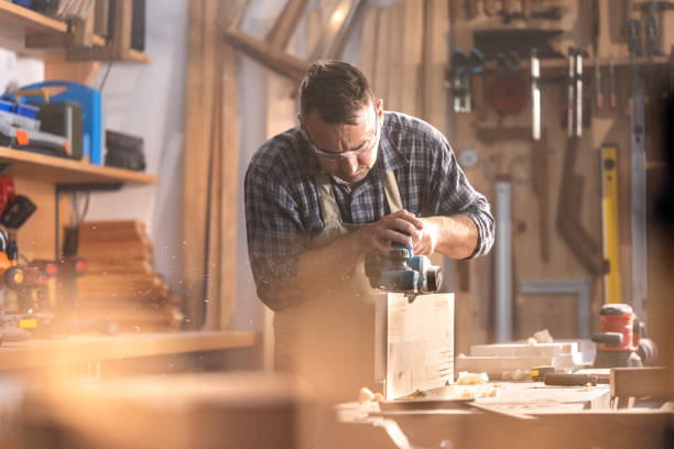 istock Mature man planing wood in workshop 1420113083