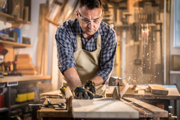 istock Mature man cutting wood in workshop 1420113137
