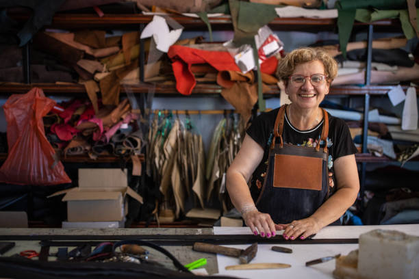 istock Smiling senior woman in a leather workshop 1420123986