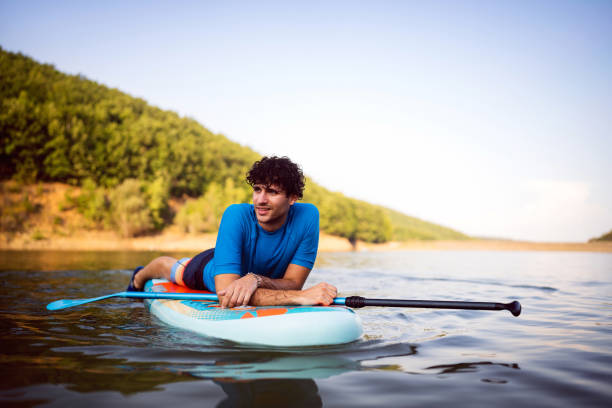 istock Caucasian man lying on a standup paddleboard, while enjoying the view 1420126888