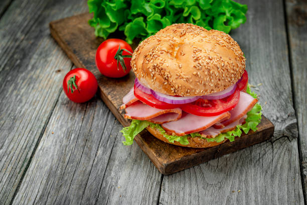 istock Sandwich with ham and vegetables on an old wooden table 1420126946