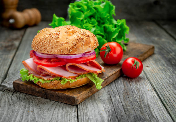 istock Sandwich with ham and vegetables on an old wooden table 1420126976