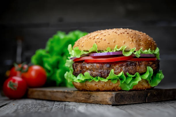 istock Fresh tasty burger on wood table 1420126984