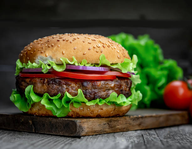 istock Fresh tasty burger on wood table 1420126995