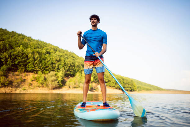 istock Caucasian man, standing on a standup paddleboard oars on the lake 1420127179