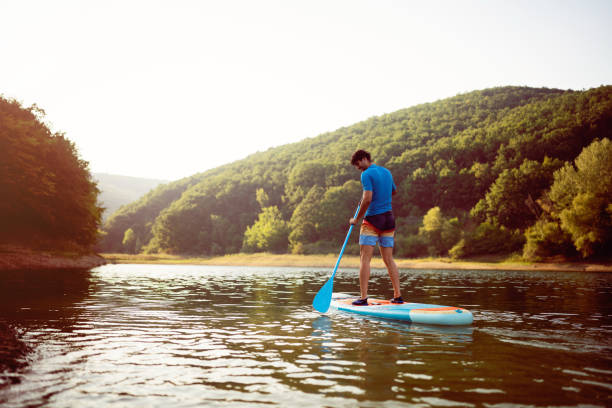 istock Caucasian man, standing on a standup paddleboard oars on the lake 1420127341