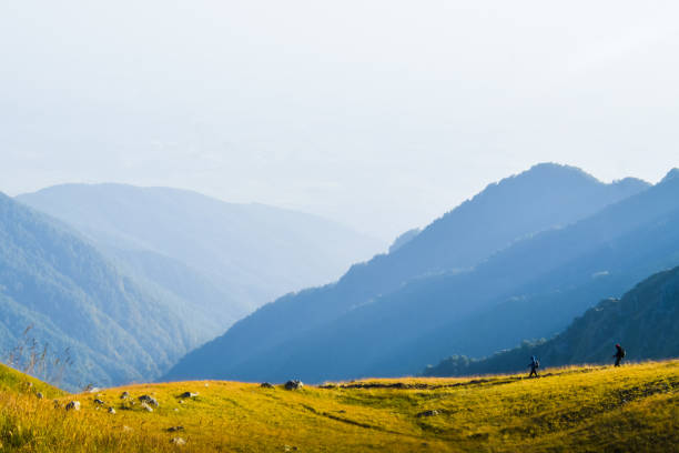 due amici escursionisti maschi in escursione di distanza sul sentiero all'aperto sul bellissimo tramonto in autunno insieme. persone attive in trekking nelle montagne del caucaso - national recreation area foto e immagini stock