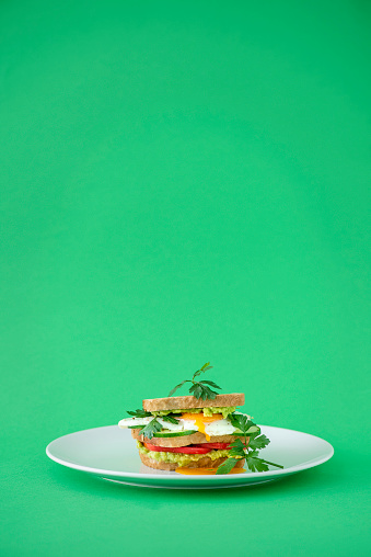 Healthy breakfast toast with avocado smash and boiled egg. Wood background. top view