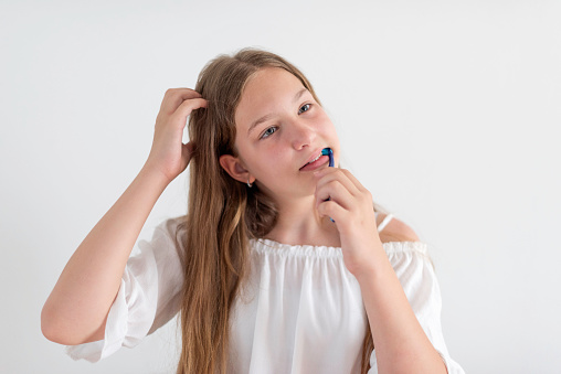 A teenage girl is brushing her teeth
