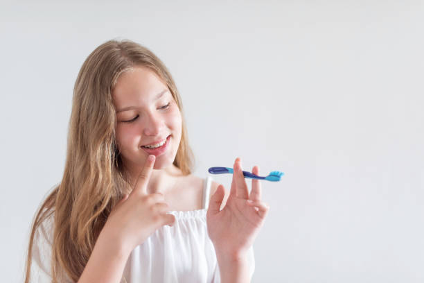 istock A teenage girl is brushing her teeth 1420137010