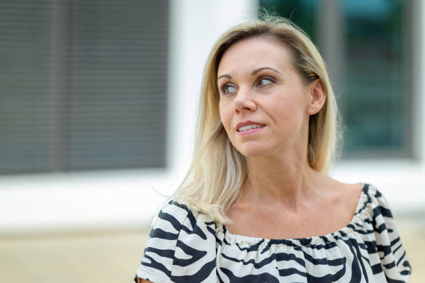 istock Attractive middle aged woman looking back over her shoulder 1420140261