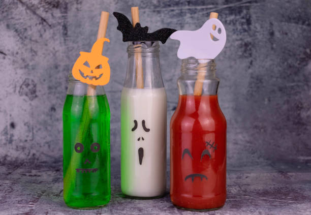istock Drink idea for Halloween party. Drinks in bottles with monster faces. Jack-o-lantern face on glass. 1420140750