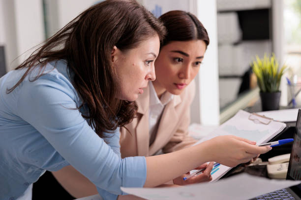 istock Colleagues analyzing financial report statistics on laptop 1420144908