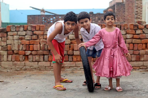 Group of elementary age children's playing with tire portrait at home.