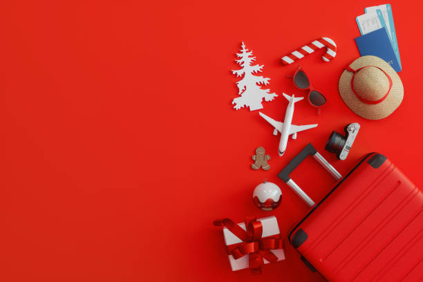 conceito de viagem de natal com mala, caixa de presente, bilhetes de avião e enfeites de natal no fundo vermelho - christmas decoration photography themes christmas ornament - fotografias e filmes do acervo