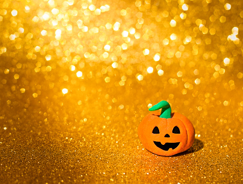 pumpkin on yellow glitter background close up