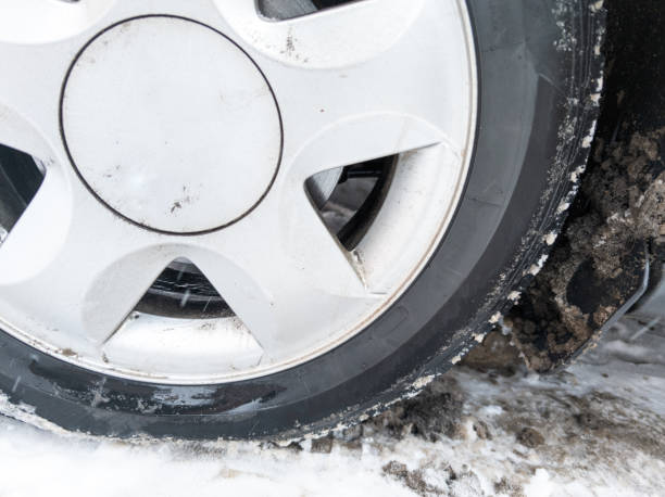 istock car wheel on slow covered surface at winter day, flat cast silver disc 1420154271