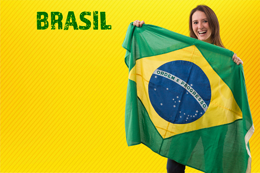 brazilian fan, woman celebrating on a yellow background.