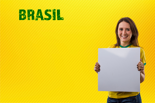 brazilian fan, woman celebrating on a yellow background.